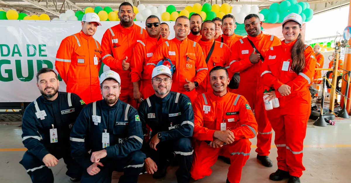 Equipe de trabalhadores reunida e sorrindo após um evento de segurança do trabalho.
