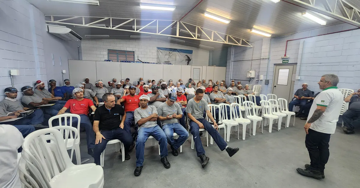 Equipe de segurança do trabalho reunida em ambiente industrial para revisar medidas de prevenção.