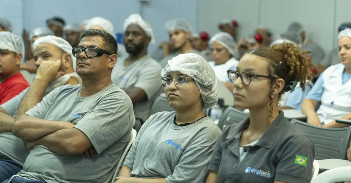 Trabalhadores atentos durante palestra de saúde e segurança no trabalho.