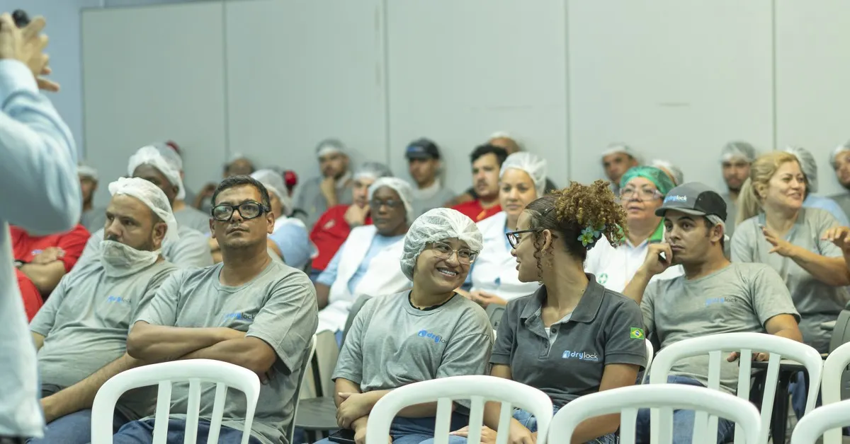 Trabalhadores atentos durante treinamento de segurança na indústria, tema da NR-12 sobre máquinas e equipamentos.