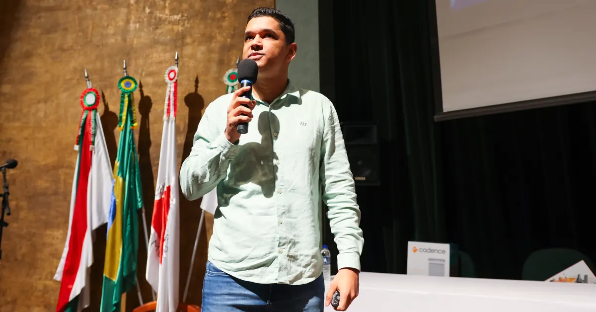 Deivson Lest ao microfone durante palestra em auditório