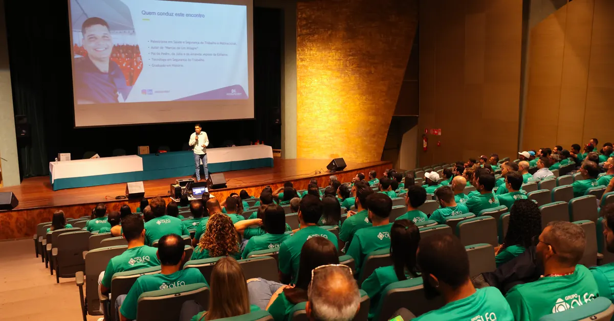 Deivson Lest no palco diante de uma plateia em auditório